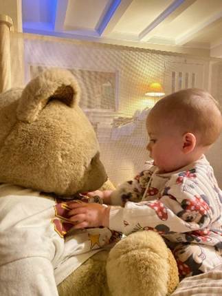 A baby sitting on a teddy bear

AI-generated content may be incorrect.